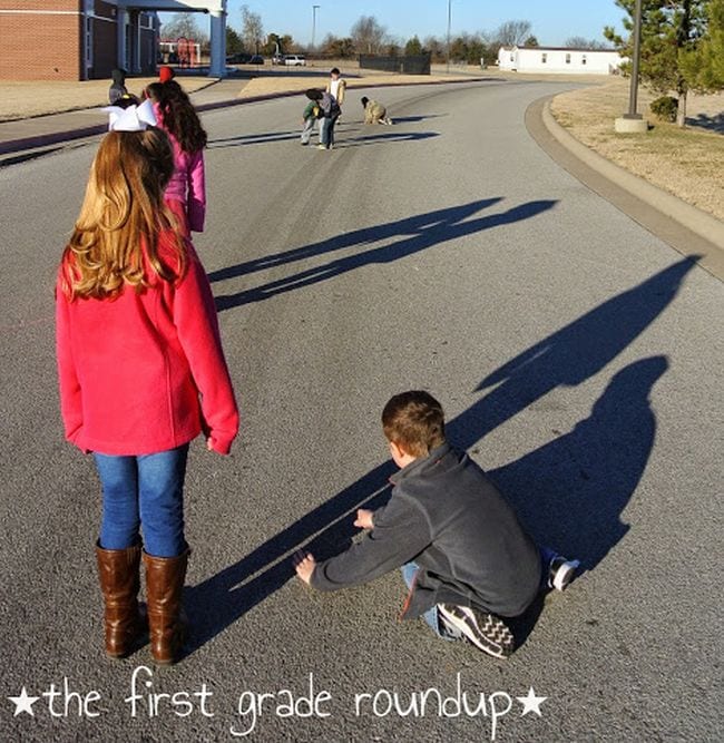 First grade science students measuring the shadows on a sunny day on the playground