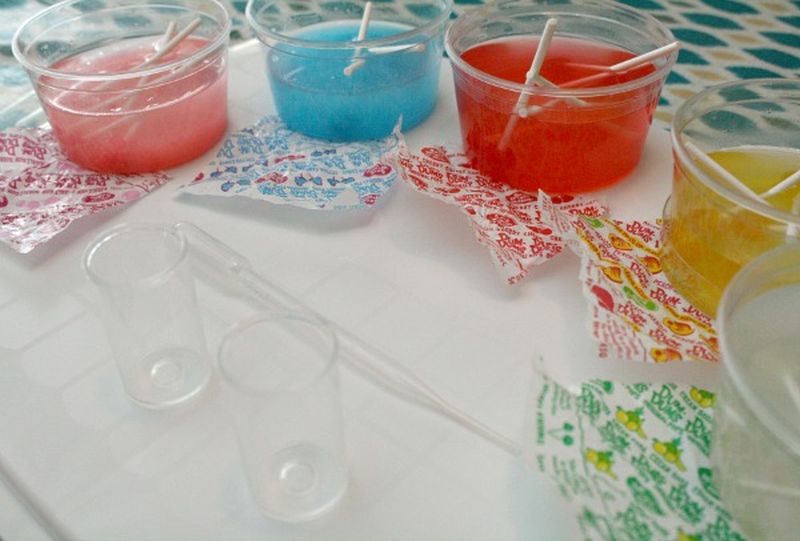 Lollipop Lab Science Experiment Plastic cups filled with water and different flavors of DumDum lollipops