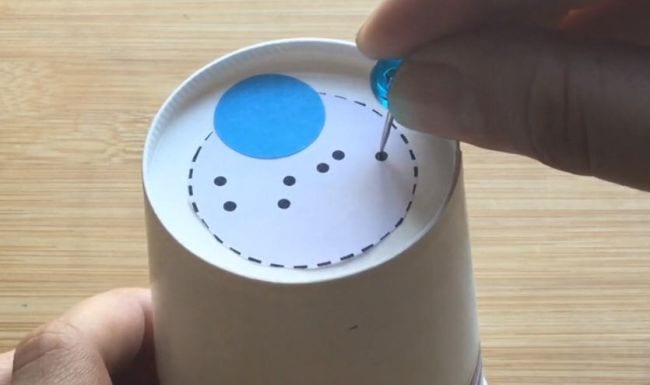 Star Projector DIY star projector for a second grade science experiment, constructed of an upside-down paper cup with seven holes punched on the bottom of it, a blue circle the size of a quarter, and a bigger white circle surrounded by dashes.