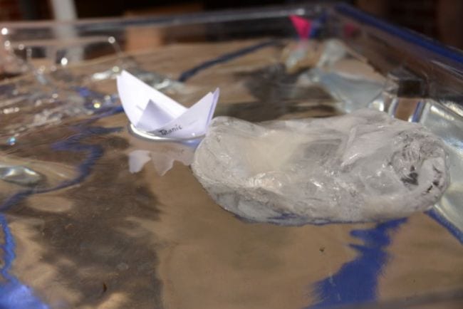 Third Grade Science Iceberg Paper boat floating in a dish with a large chunk of ice