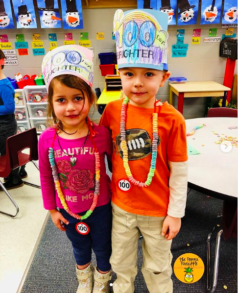Cheerios A young boy and girl stand proudly wearing their 100th day Cheerio necklaces and crowns
